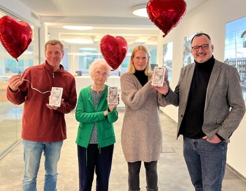 Thomas Kinner, Trauthilde Gatz und Sandra Eggert (v.l.) freuen sich über ein neues iPhone 15. Carsten Wittig, Leiter der GSW-Kundencenter, überreichte den Gewinnern – passend zum Valentinstag – zudem einen Herz-Luftballon.