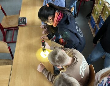 Energieprojekt in Grundschulen. Taschenlampe als Lichtquelle für Solarpaneel bei einem Auto